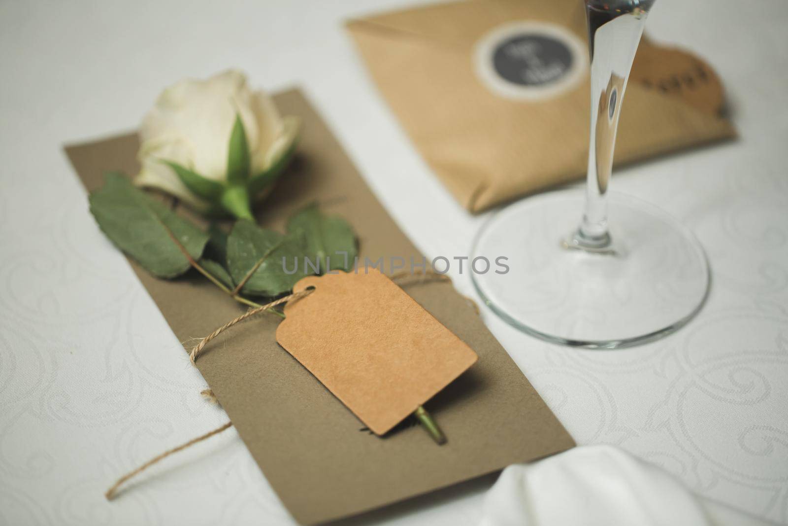 A nameplate on the wedding table with a live rose by StudioPeace