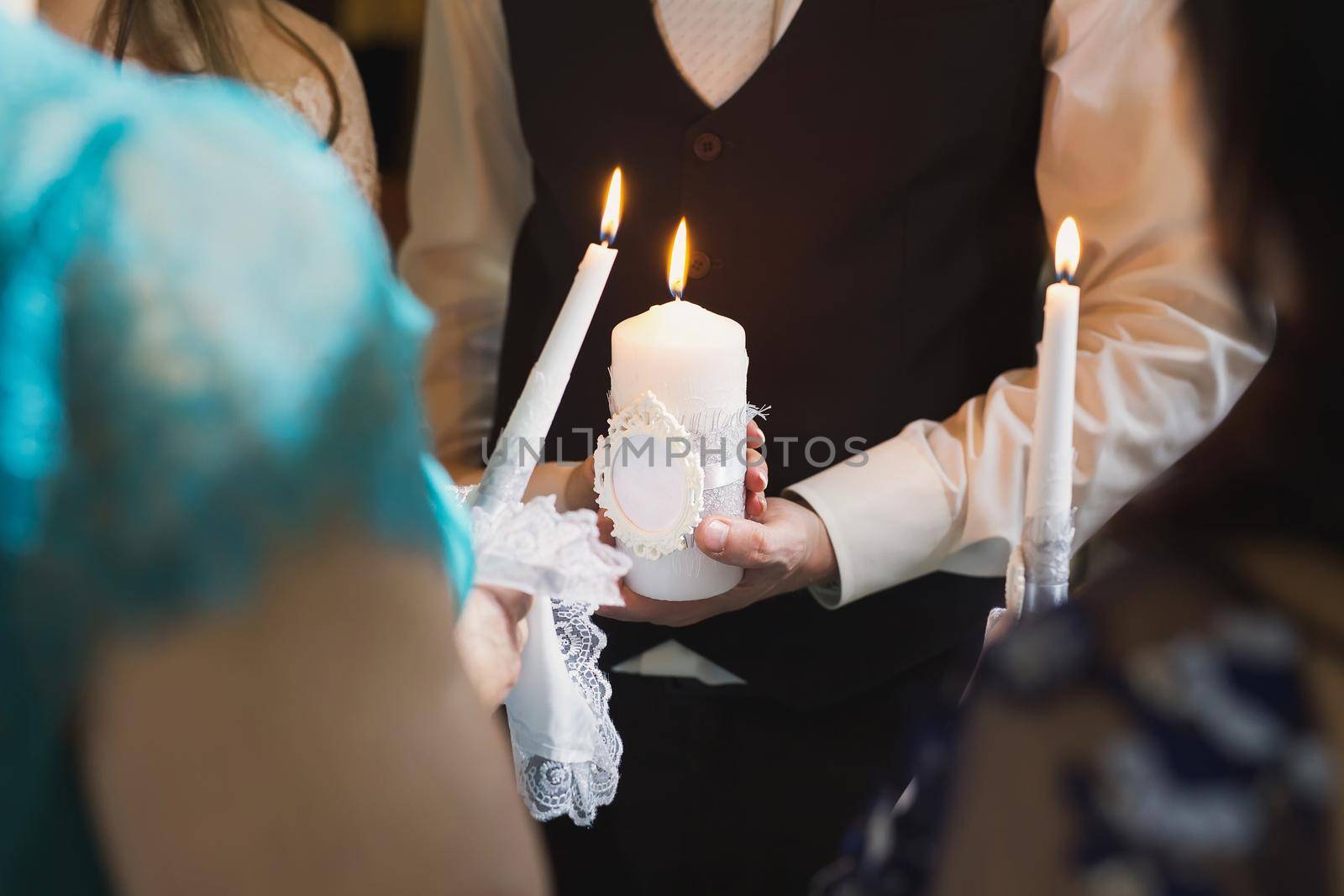 Wedding ceremony, paraphernalia, the bride and groom hold a large candle in their hand. by StudioPeace