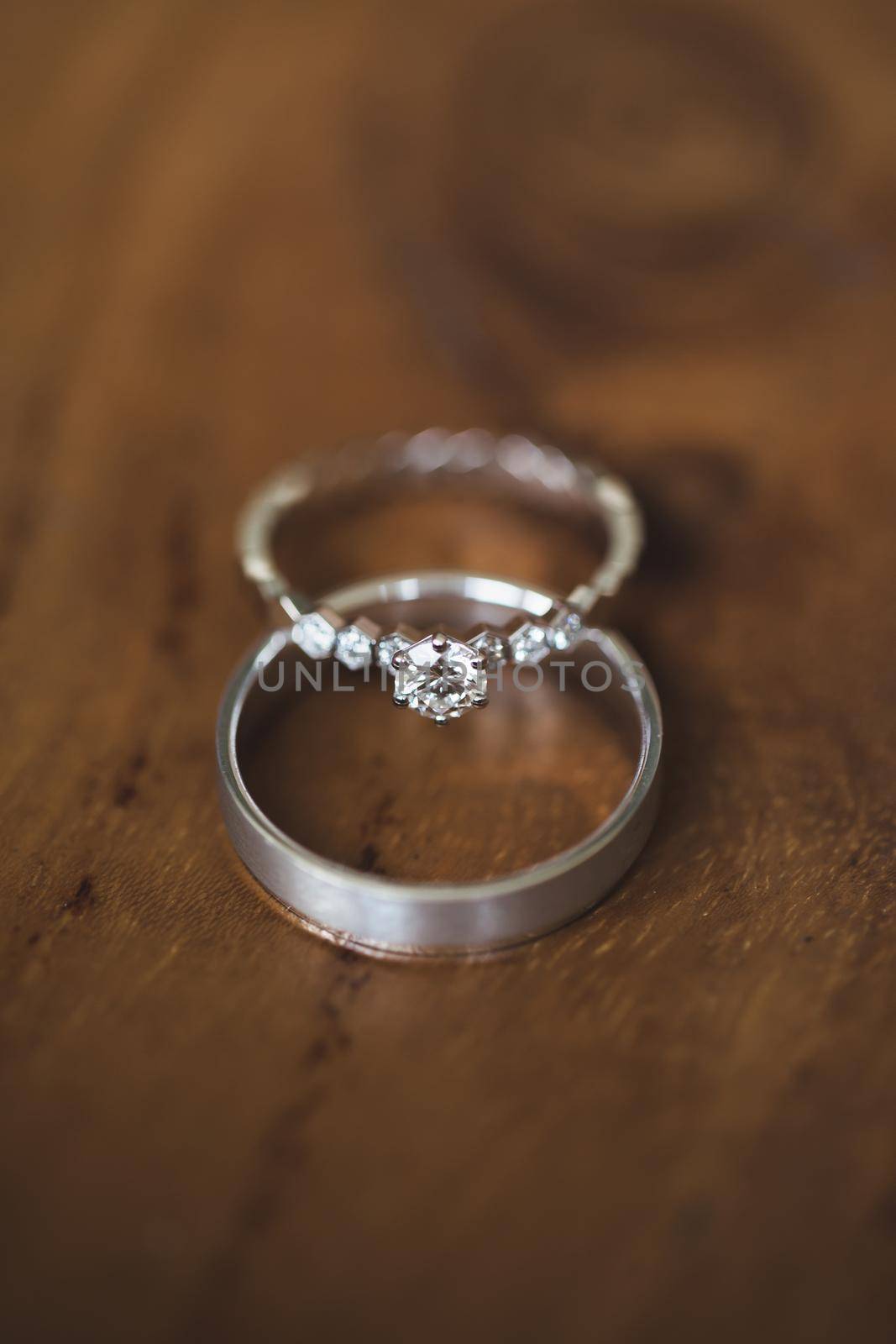 Wedding rings on a wooden texture close-up.