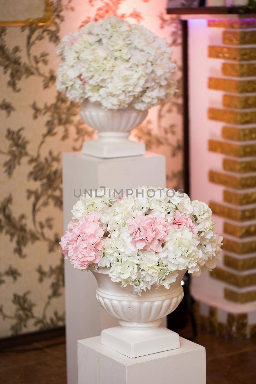 Wedding decor of white and pink flowers in huge white vases. by StudioPeace