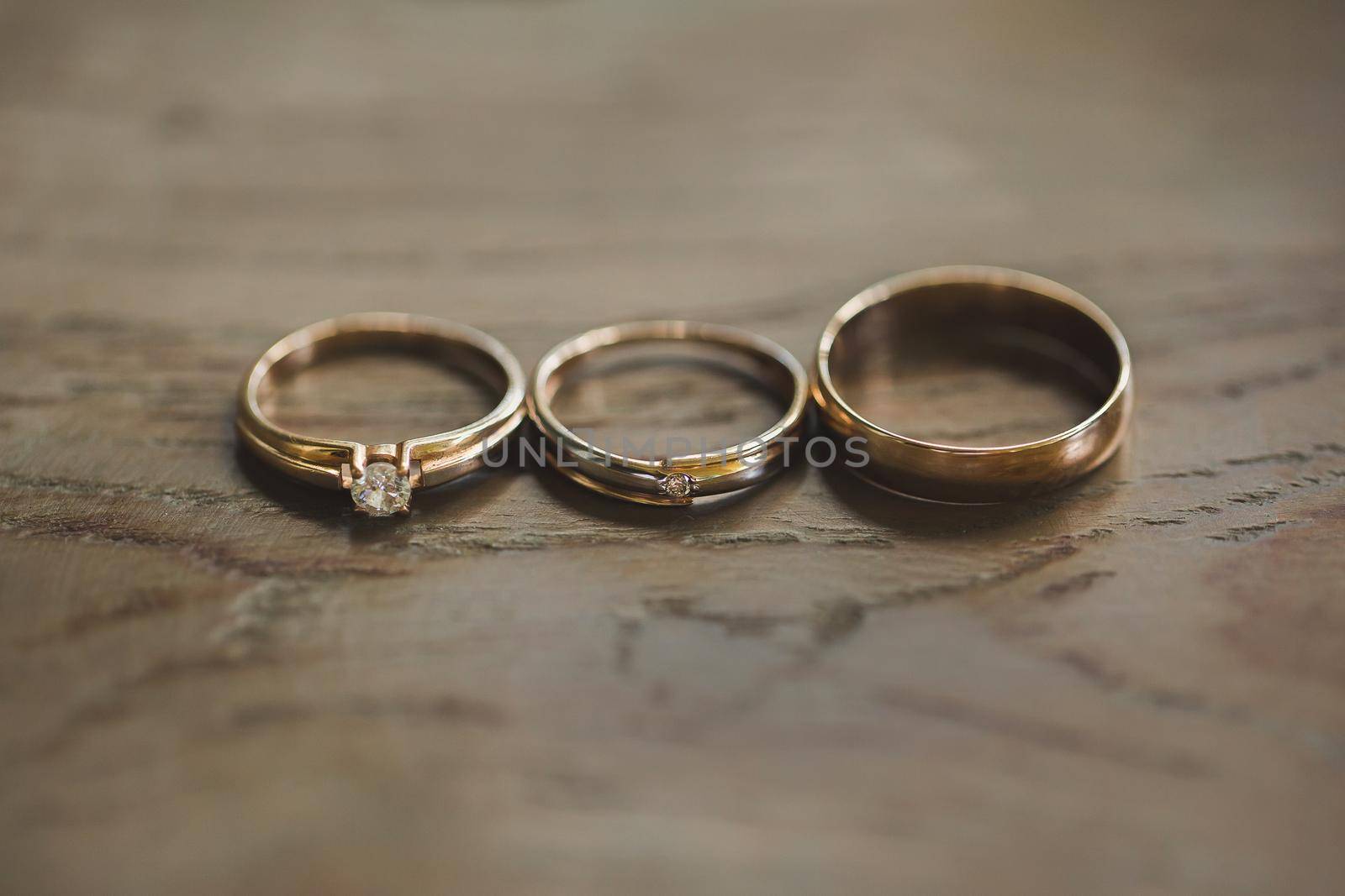 Wedding rings on a wooden texture close-up by StudioPeace