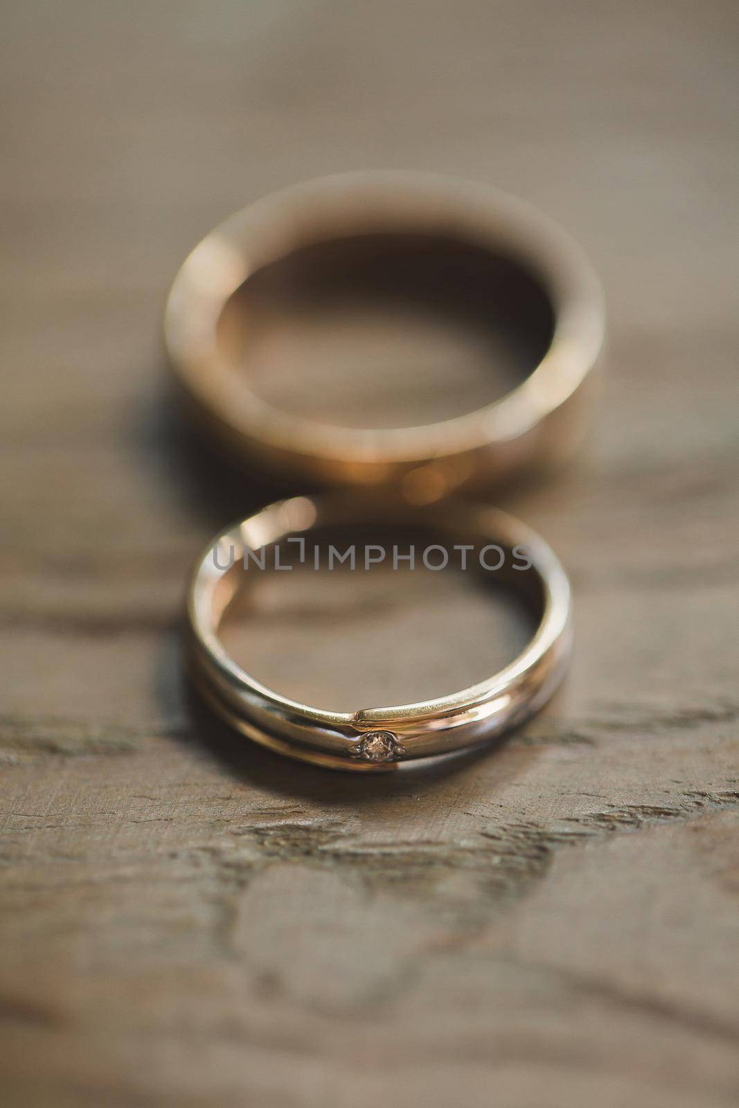 Wedding rings on a wooden texture close-up.