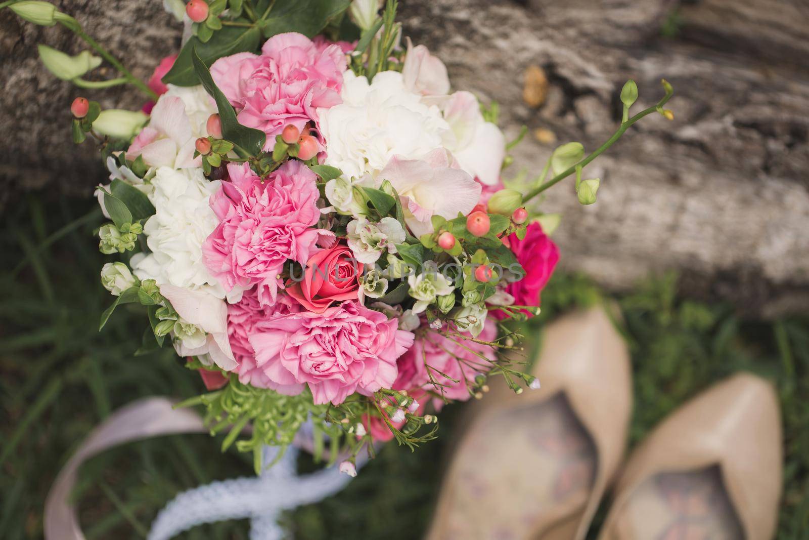 Wedding shoes and a bouquet on the grass by StudioPeace