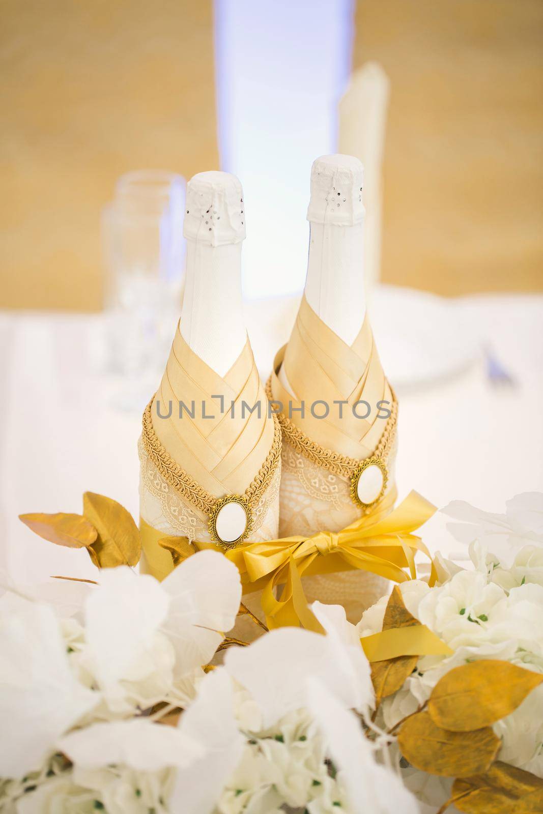 Decorated bottles of champagne on the newlyweds table