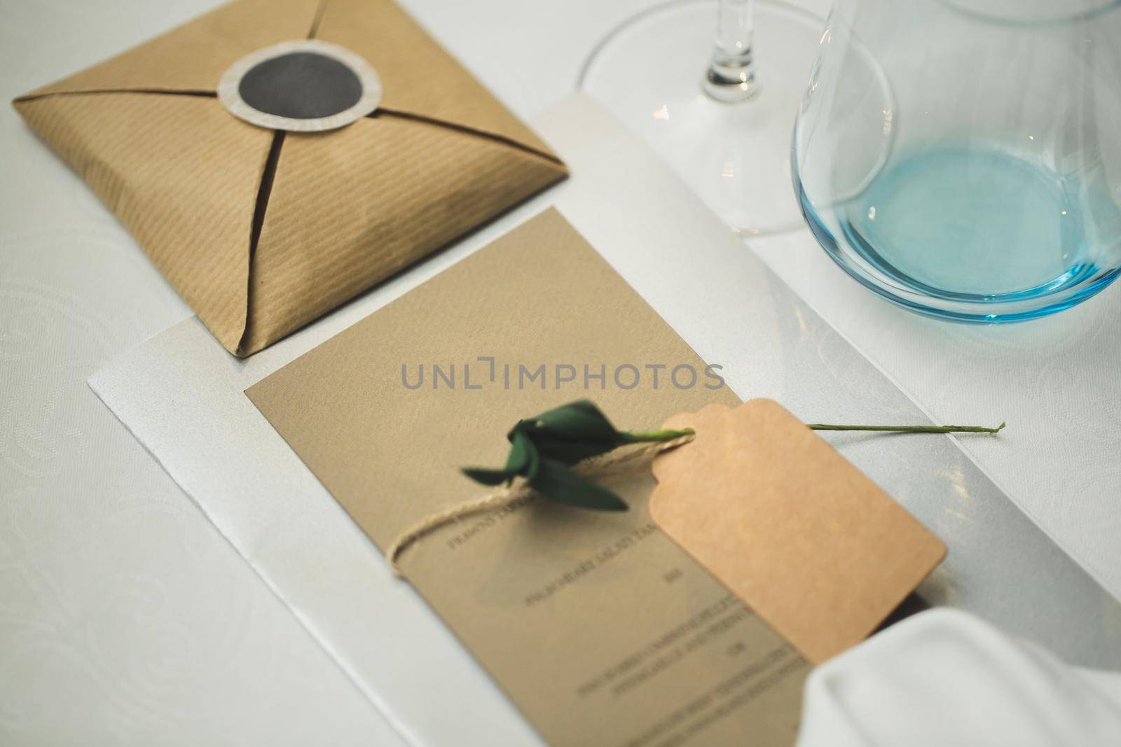 A nameplate on the wedding table with a live rose by StudioPeace