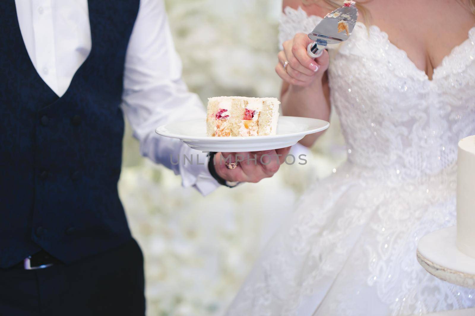 The bride and groom cut a gorgeous wedding cake at a banquet.