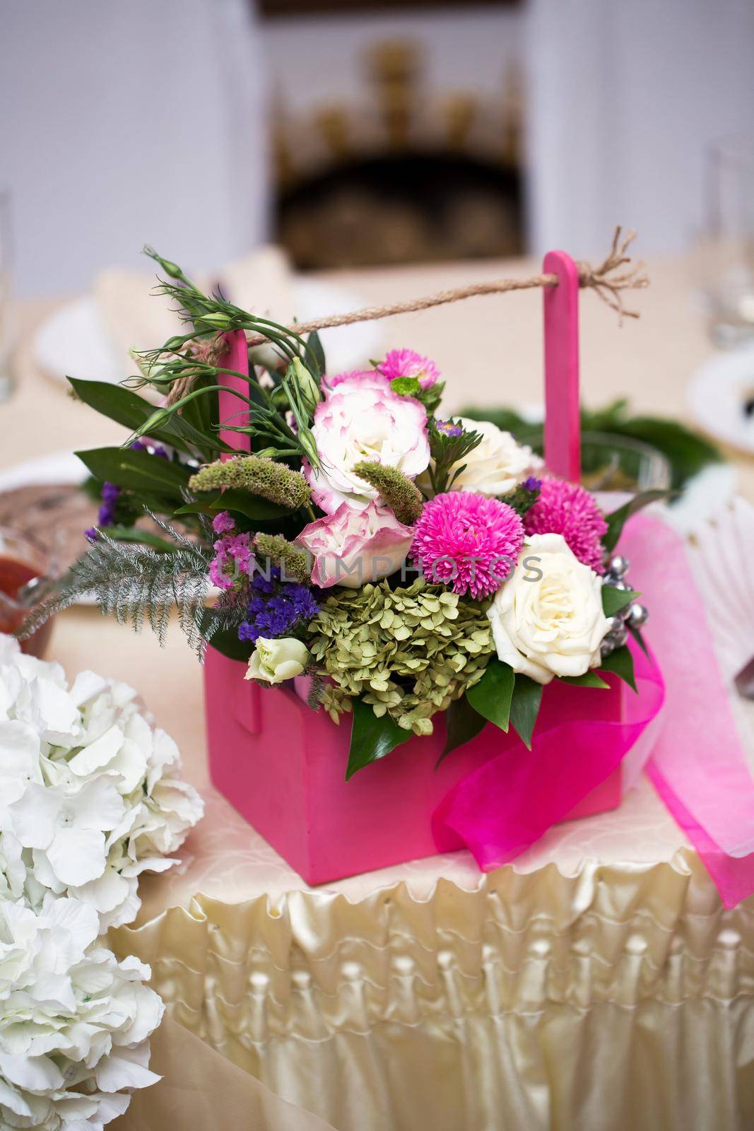 Gift of flowers in a pink basket at a wedding. by StudioPeace