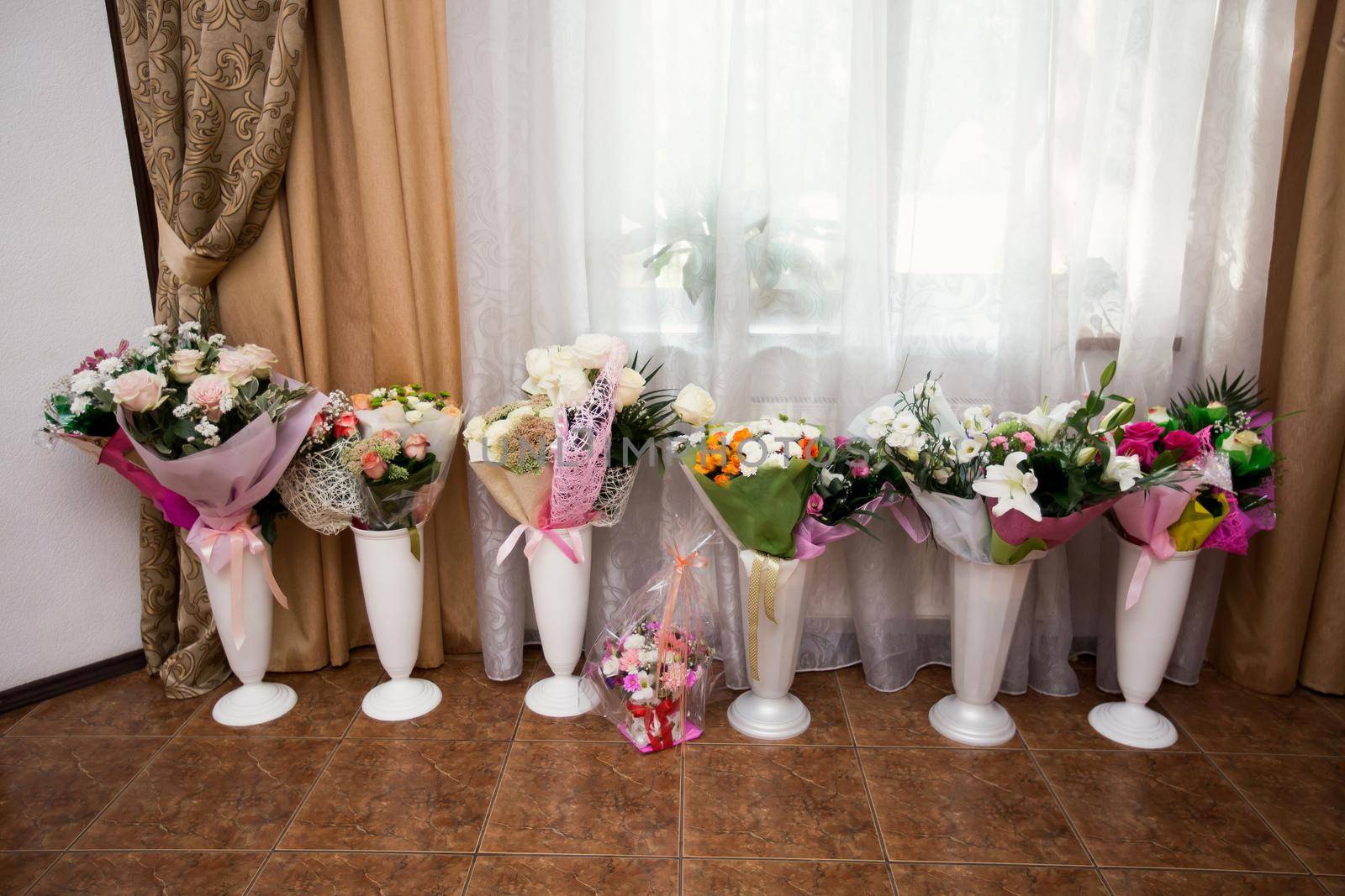 Gifts from bouquets of flowers in vases at the wedding. by StudioPeace