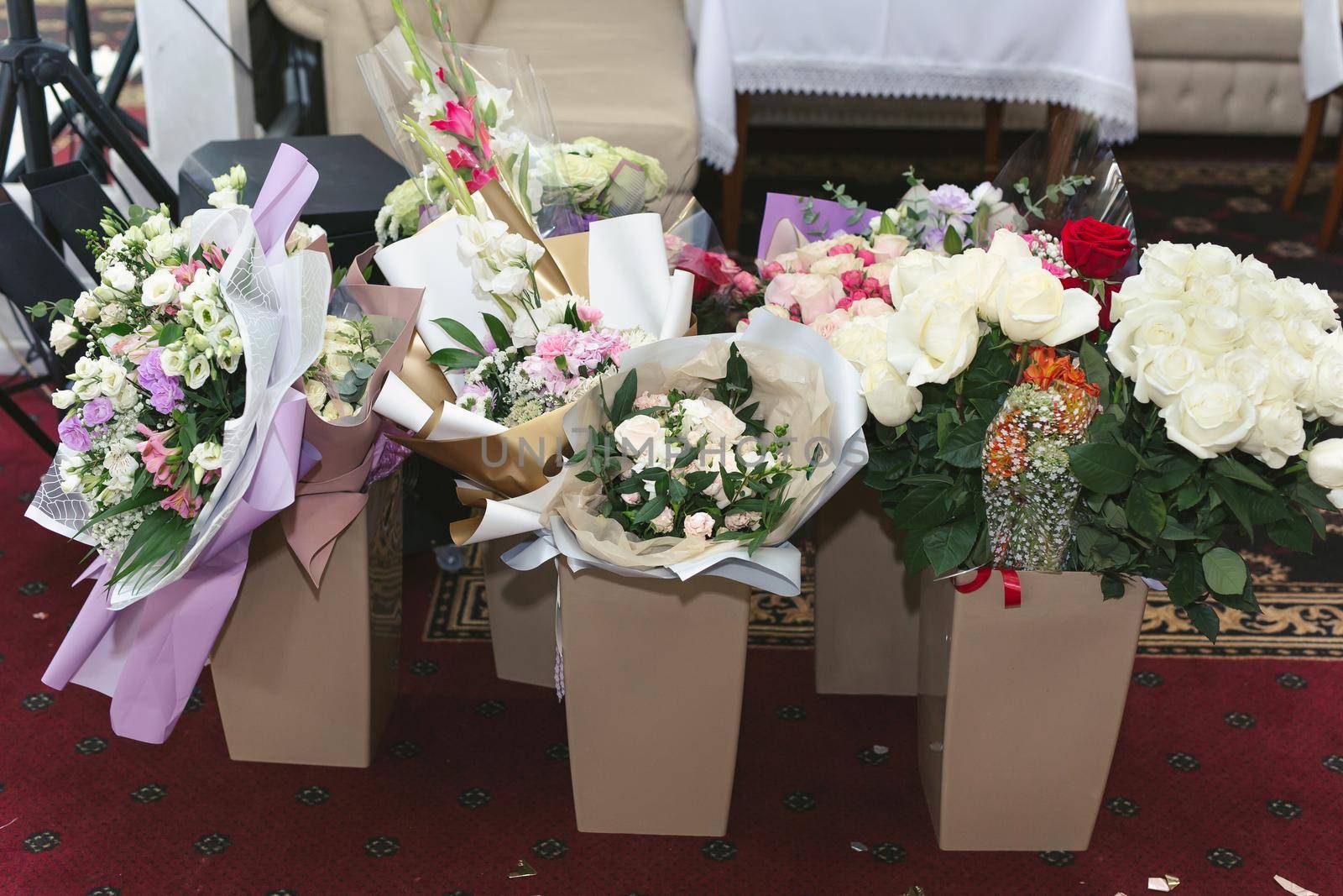 Vases with bouquets of flowers. storage of donated flowers at a banquet in a restaurant by StudioPeace