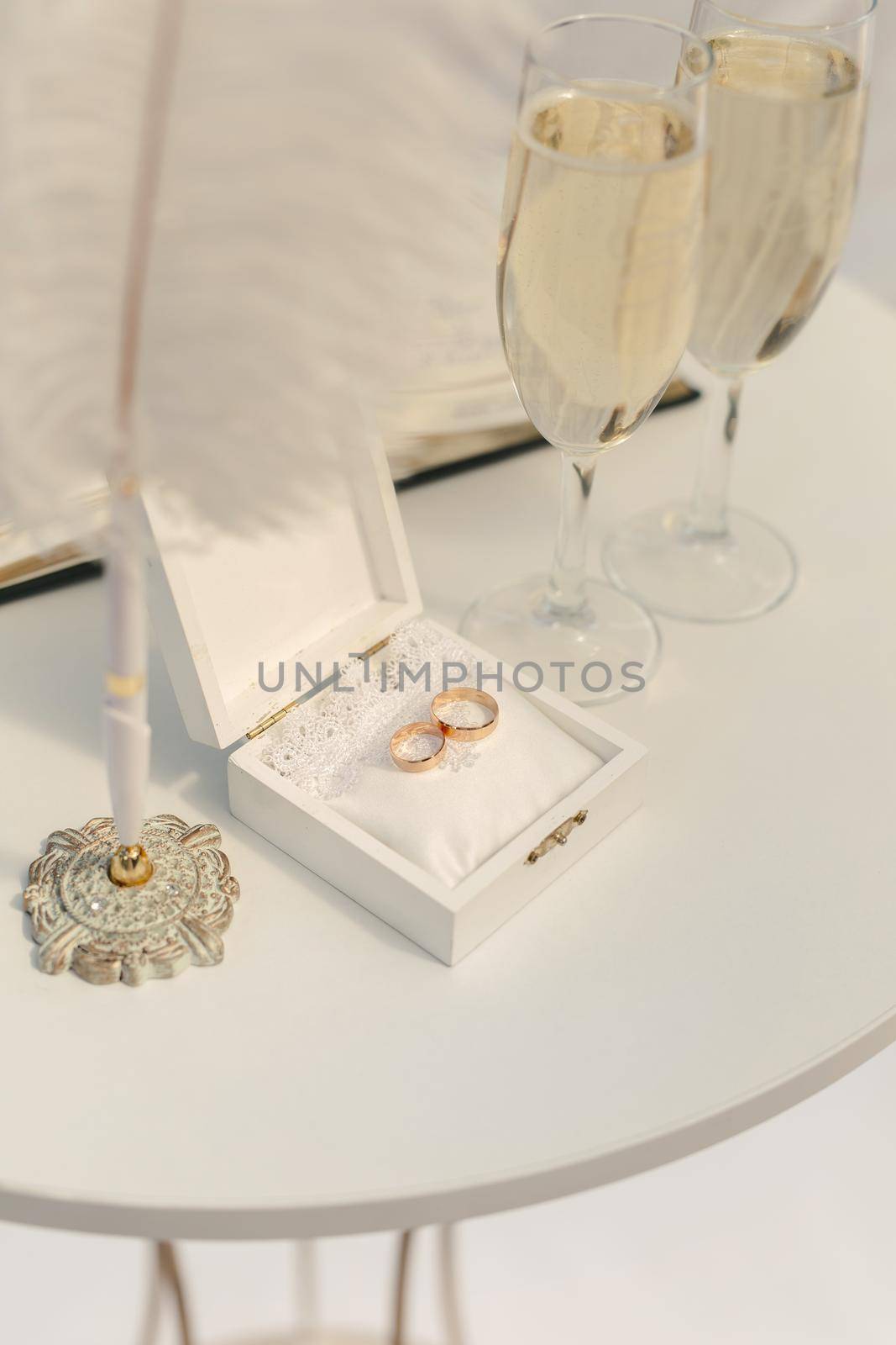 A box with wedding rings and gold sequins, champagne glasses, flowers by StudioPeace