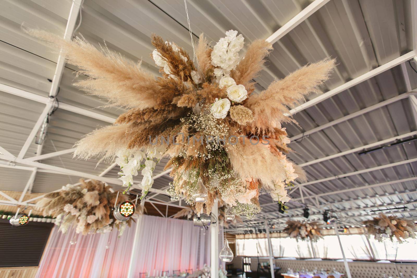 Wedding decor for newlyweds at a banquet. Floristry of dried flowers and candles in boho style.