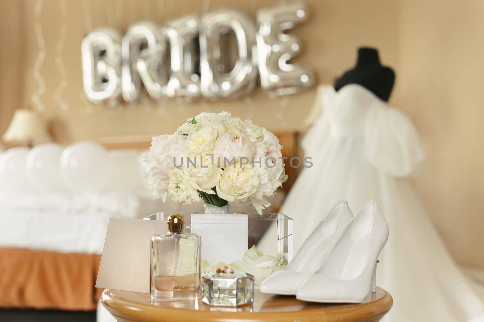 Chic wedding dress and veil on a mannequin in the bride 's gathering room by StudioPeace