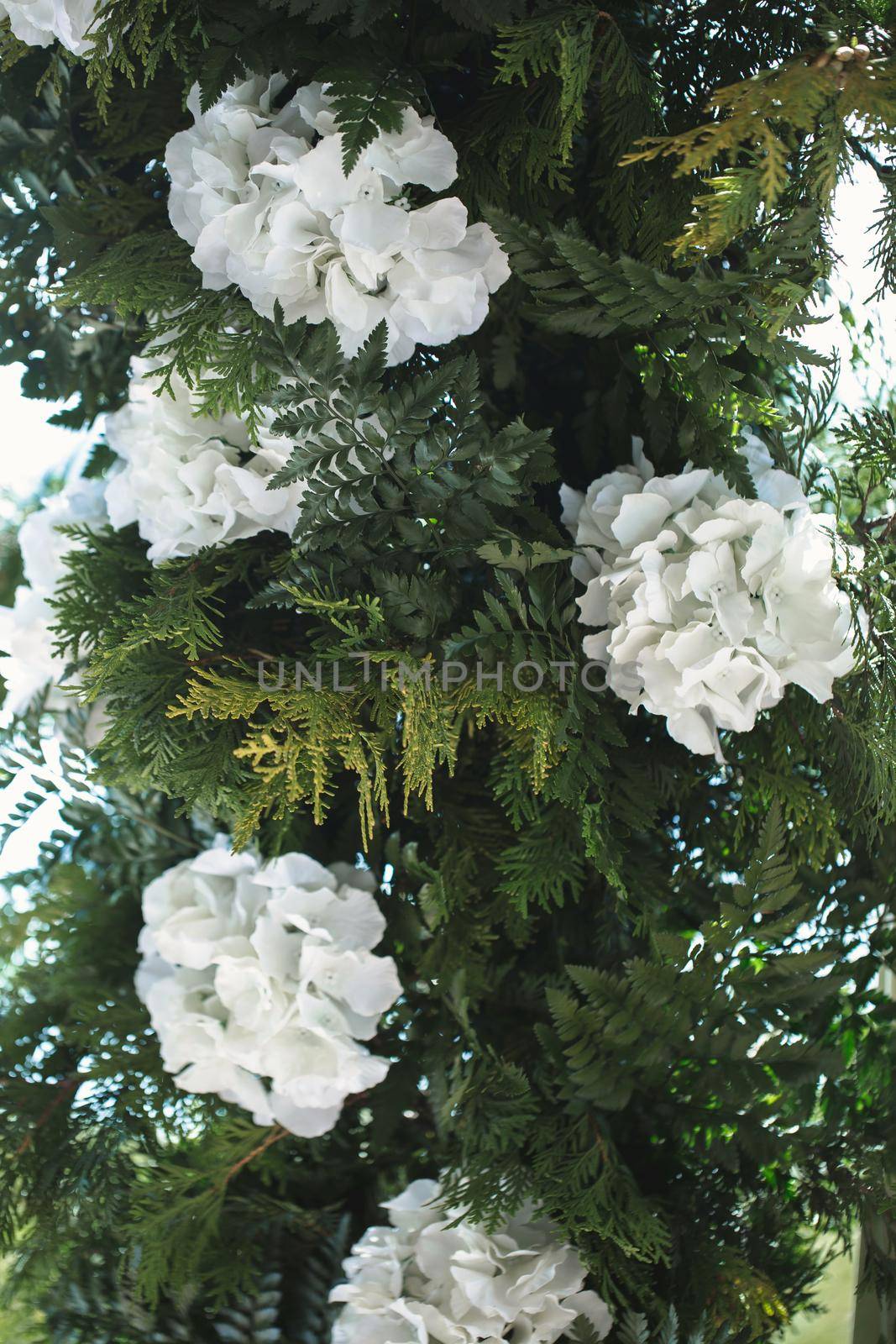 Wedding decor made of green branches and white flowers.