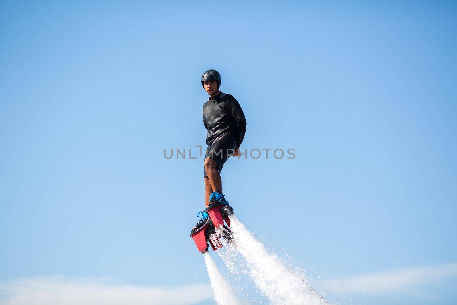 A rider on a flyboard in the ocean does difficult stunts. by StudioPeace