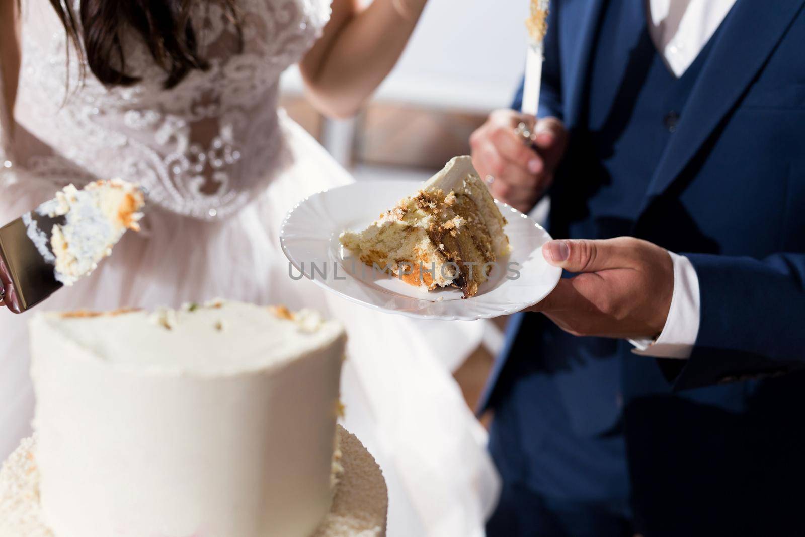 The bride and groom cut a gorgeous wedding cake at a banquet by StudioPeace