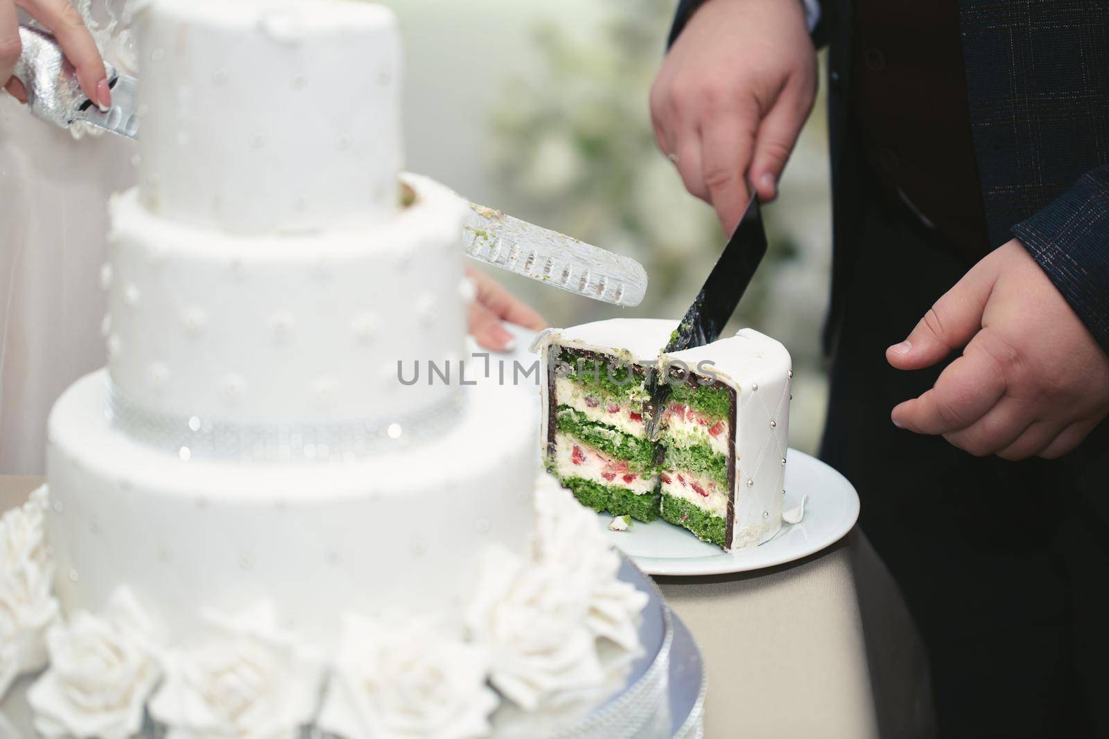 The bride and groom cut a gorgeous wedding cake at a banquet by StudioPeace