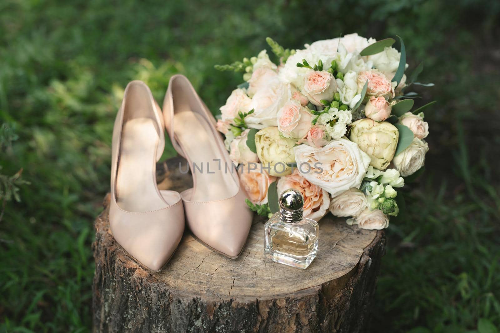 Beautiful bridal bouquet of white roses on a wooden stump. Stylish, leather shoes bride beige. Wedding in vintage style