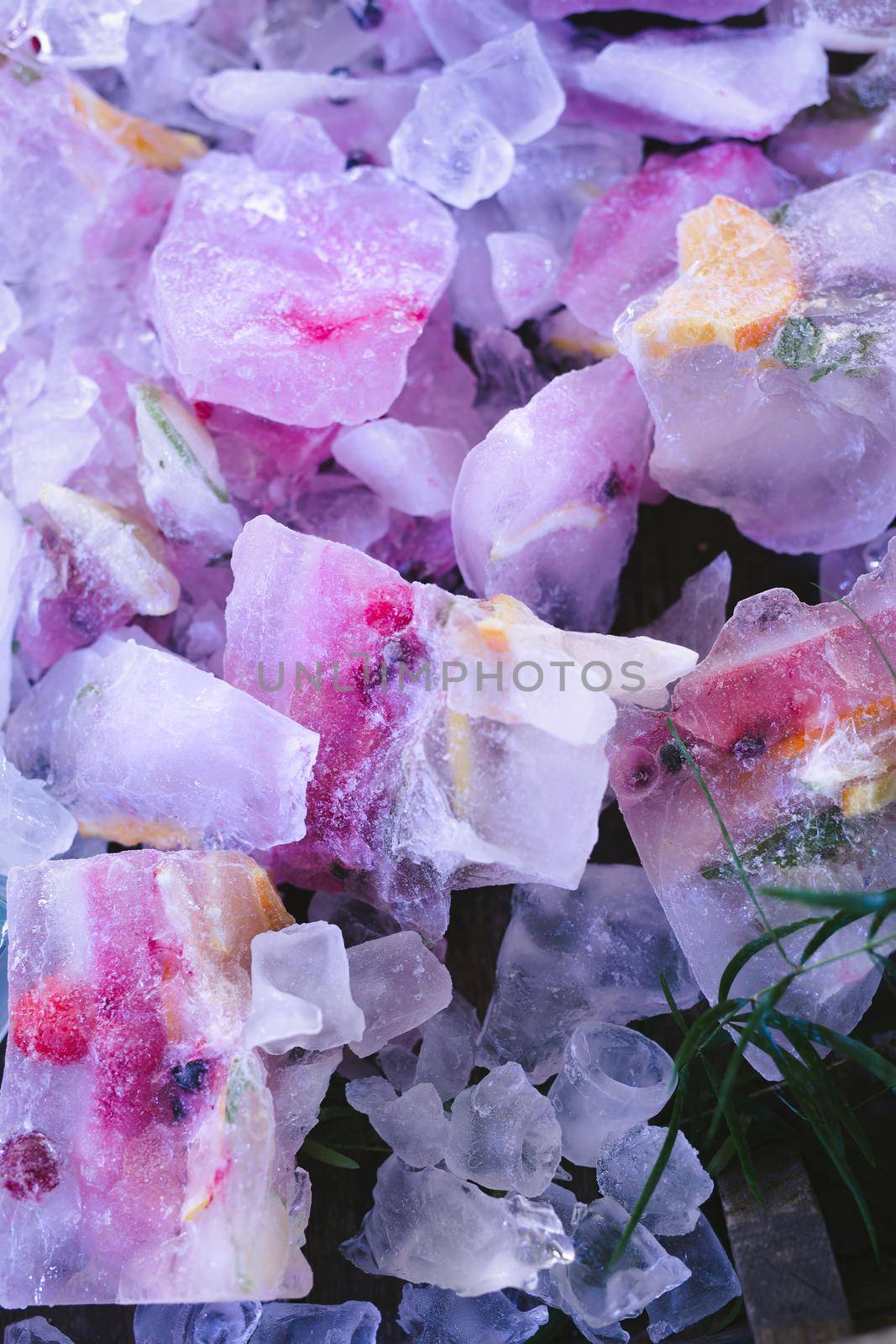 Fresh berries and fruits frozen in ice cubes.