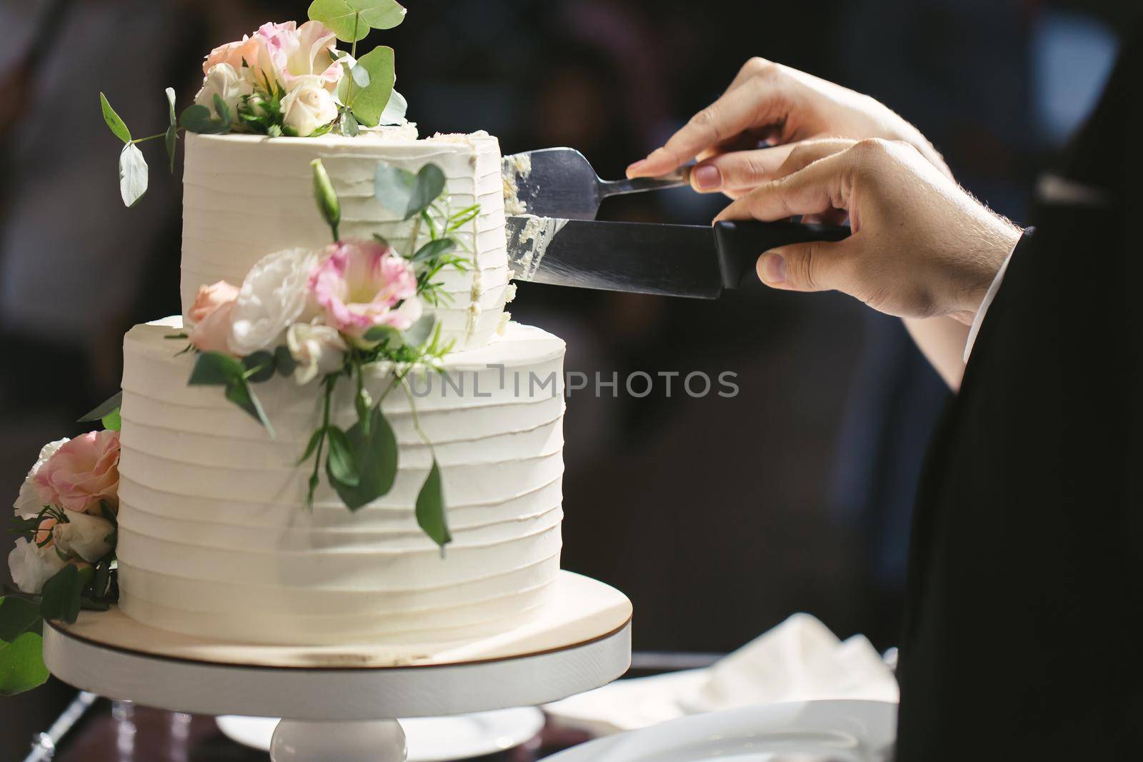 The bride and groom cut a gorgeous wedding cake at a banquet.