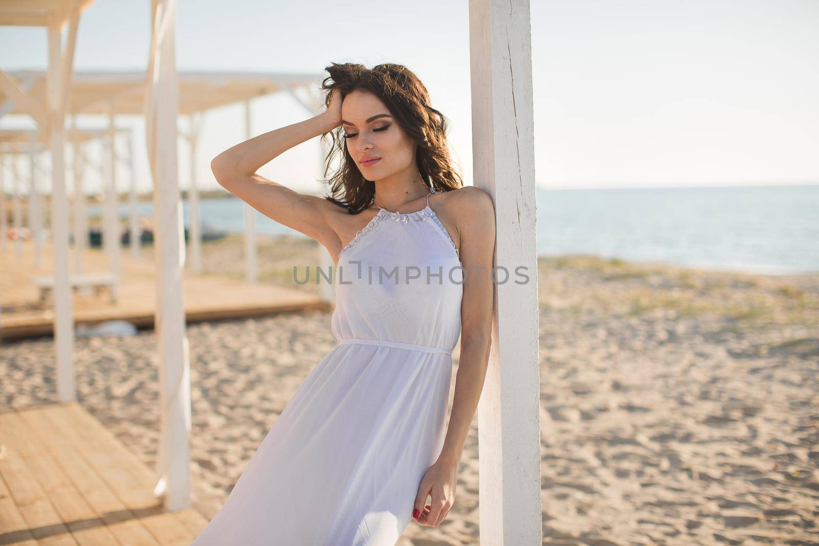 Beautiful girl on the beach in a white dress.