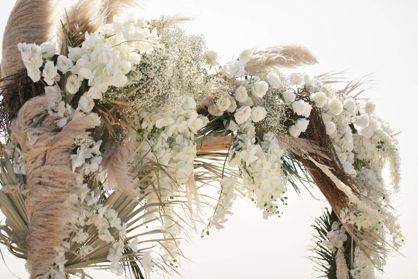 Fresh flowers and dried flowers on the wedding arch.