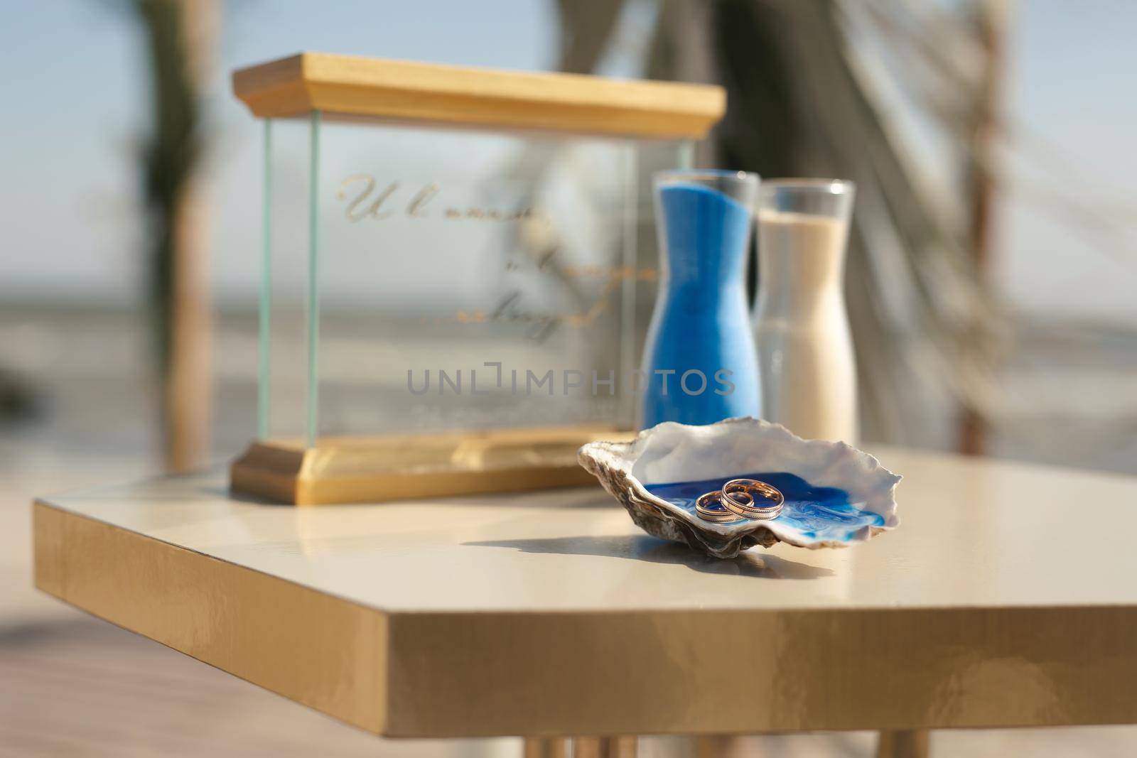 Multicolored sand in a crystal vase close-up during a symbolic wedding ceremony in a nautical style on a sandy beach in front of the ocean by StudioPeace
