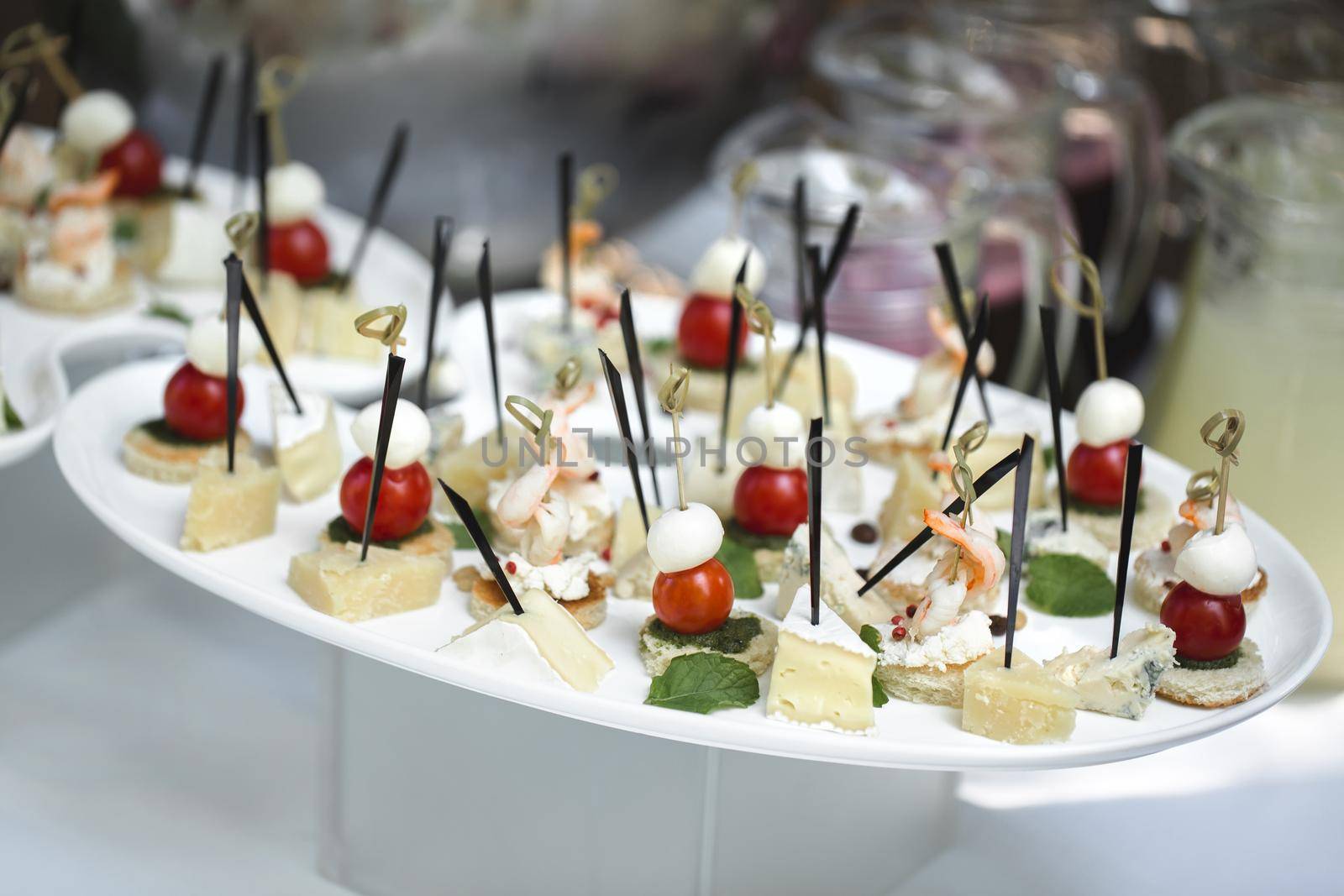 Catering table buffet dinner, beautifully decorated banquet with variety of different food snacks and appetizers on corporate birthday party event or wedding reception, canape, delicatessen setting