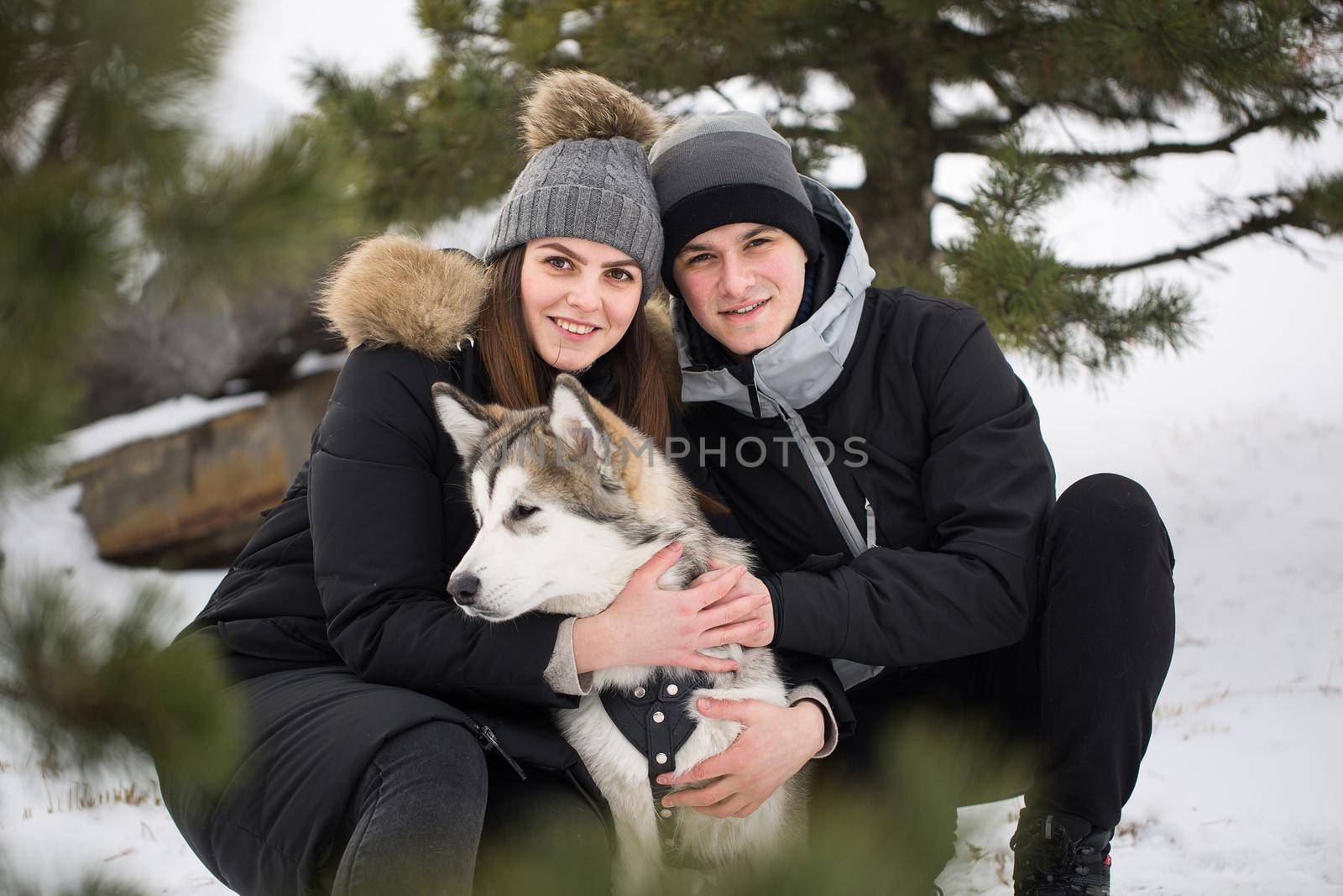 Beautiful family, a man and a girl in winter forest with dog. Play with the dog Siberian husky by StudioPeace