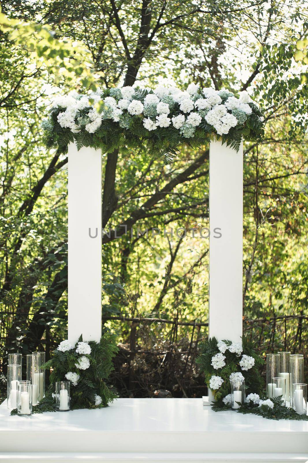 Wedding arch with white flowers and candles