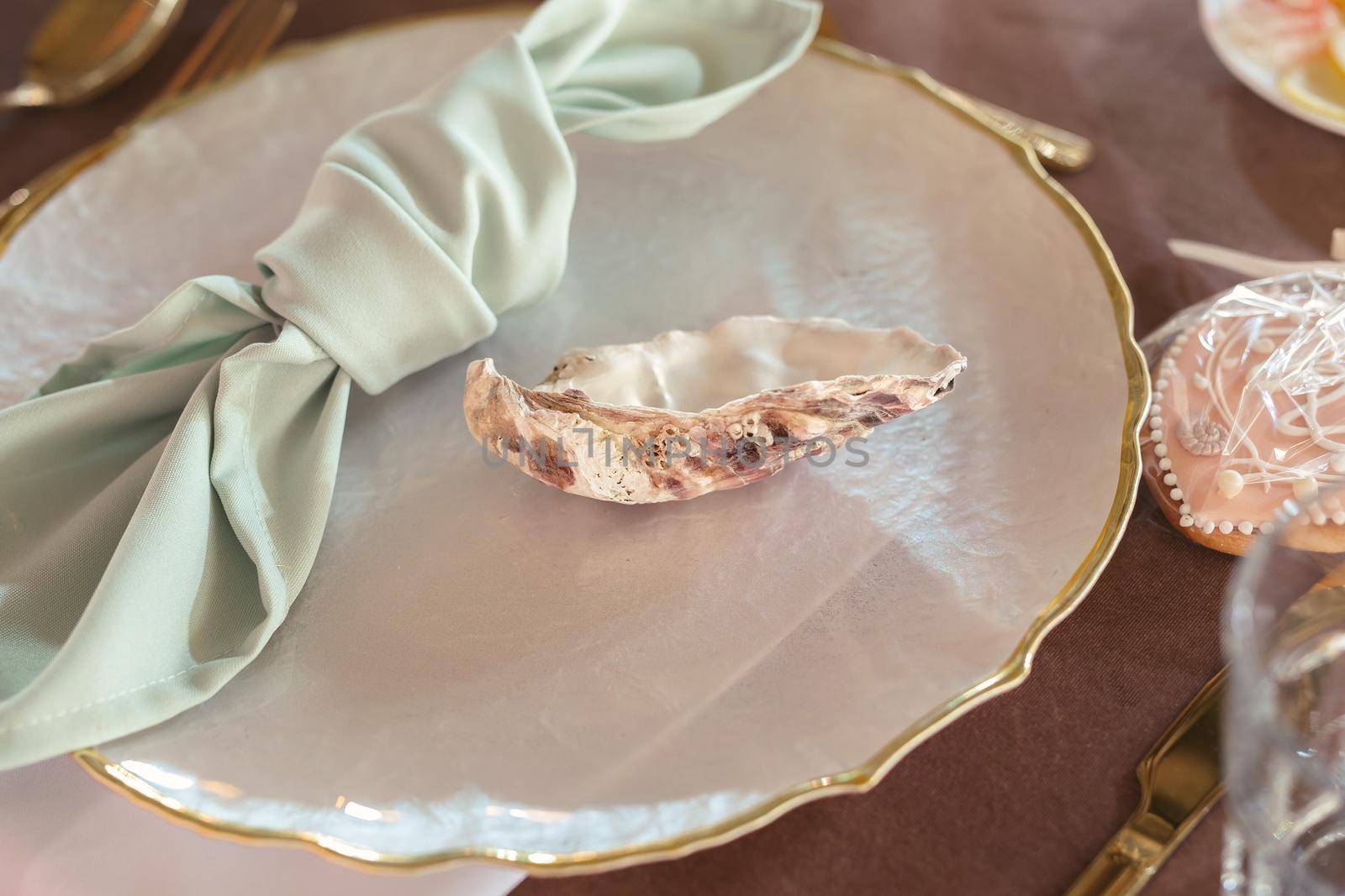 Wedding table setting in a nautical style. A shell and a napkin in the guests' plate.