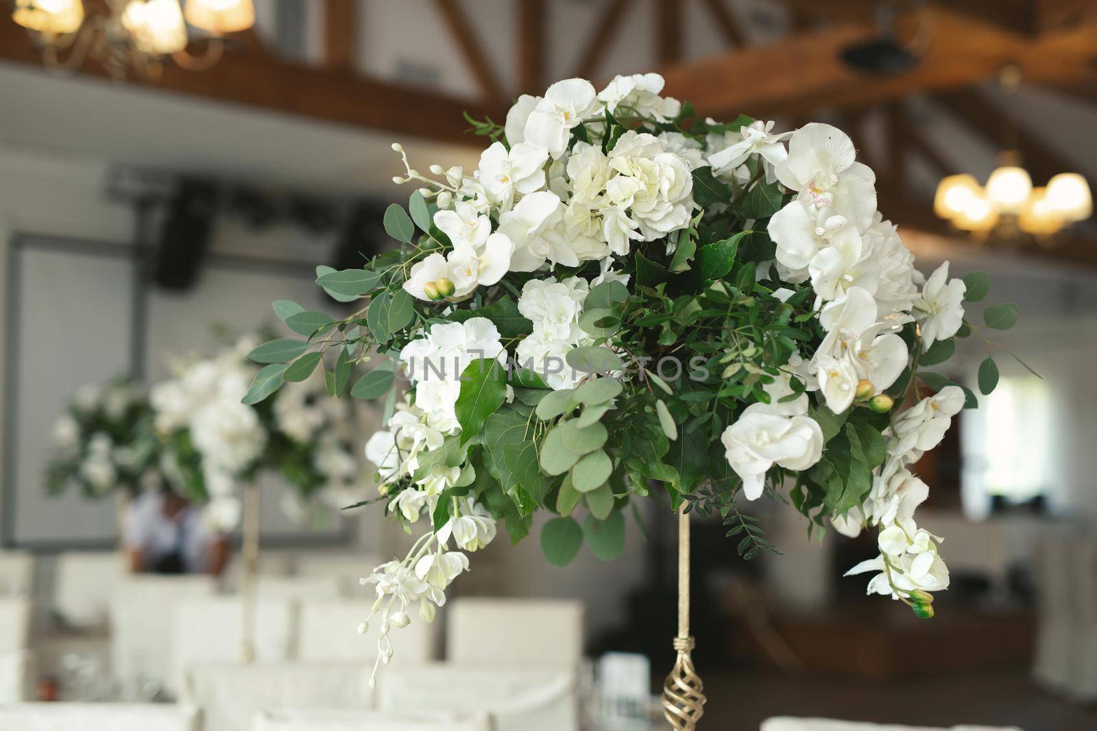 Wedding floral decor in white at a banquet in a restaurant.
