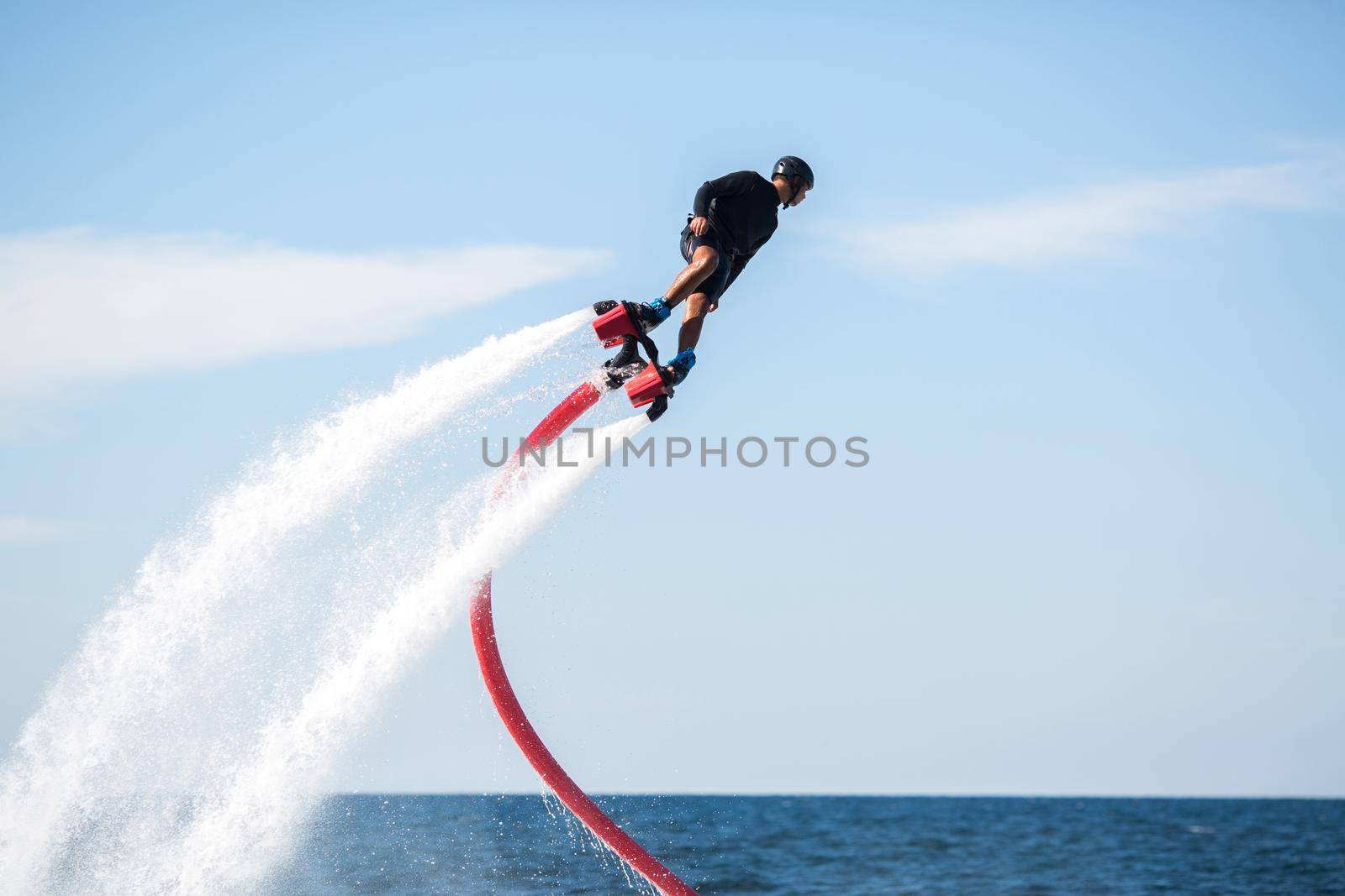 Rider on a flyboard in the ocean does difficult stunts. by StudioPeace