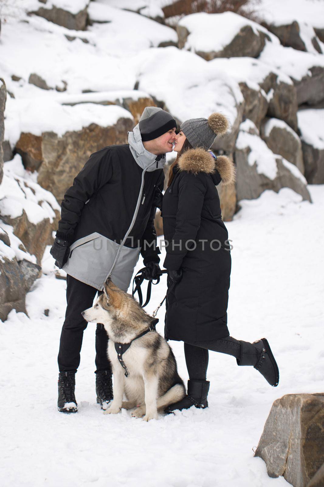 Beautiful family, a man and a girl in winter forest with dog. Play with the dog Siberian husky.