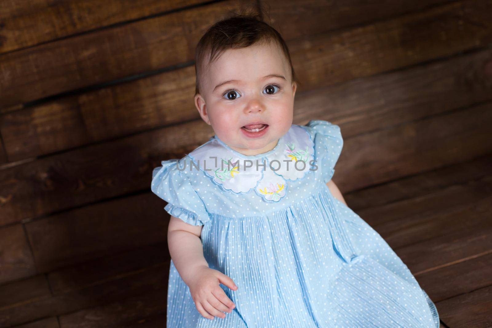 Beautiful girl in blue dress on wooden background. by StudioPeace