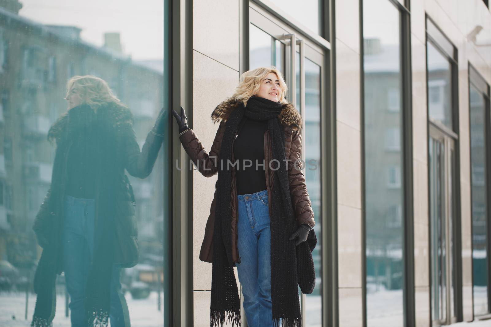 beautiful woman posing near the glass building