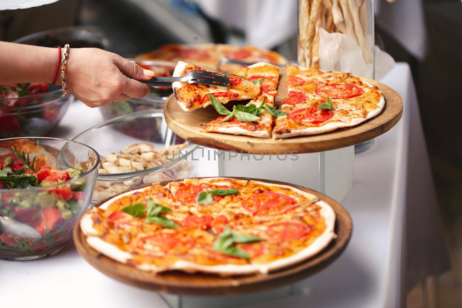 Self-service at the buffet. A variety of pizza and salads by StudioPeace