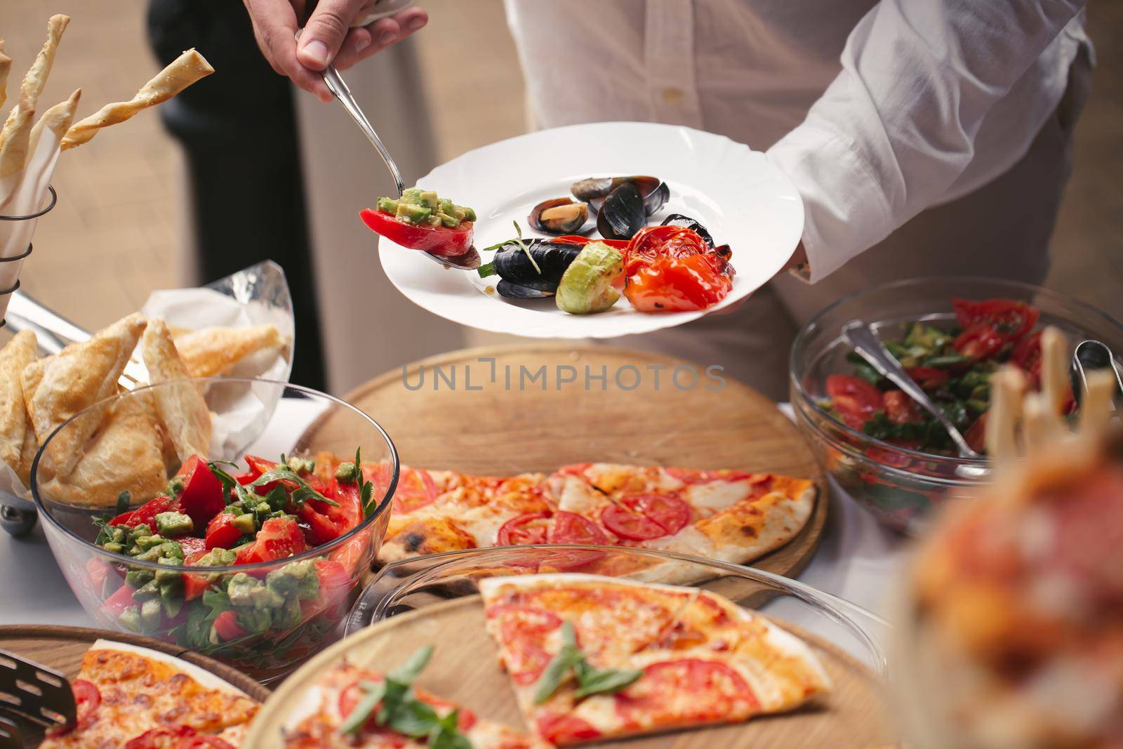 Self-service at the buffet. A variety of pizza and salads.