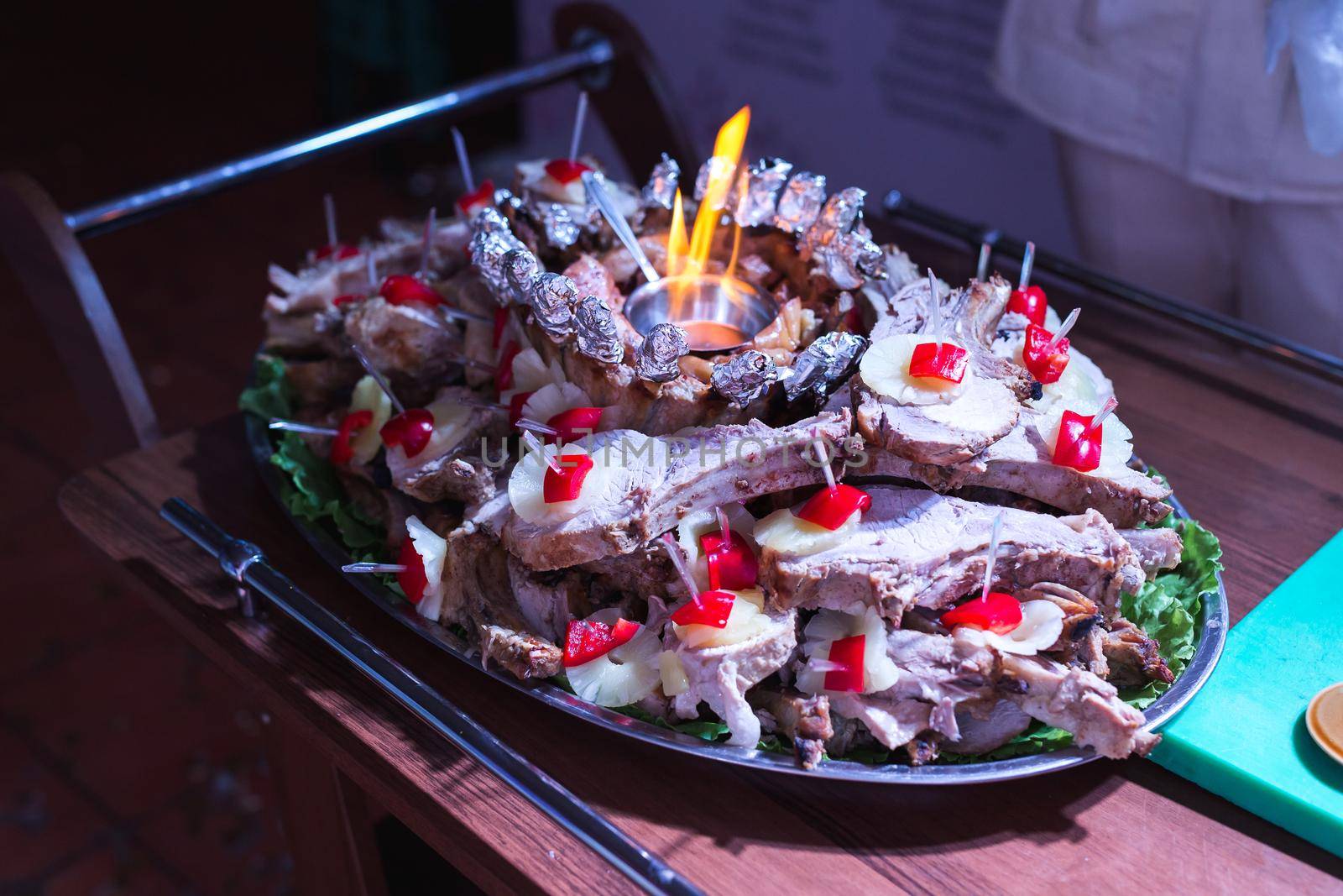 A waiter takes out a square of lamb at a wedding banquet.