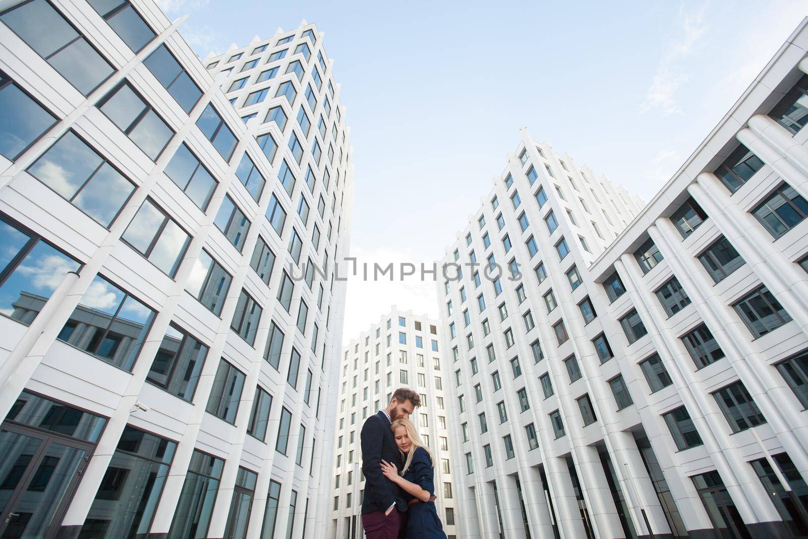 Man and woman hugging in the background is the building of the business center.
