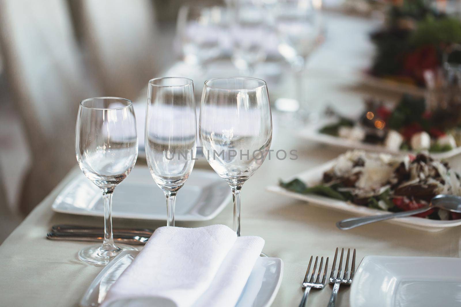 Table at a luxury wedding reception. Beautiful flowers on the table. Serving dishes, glass glasses