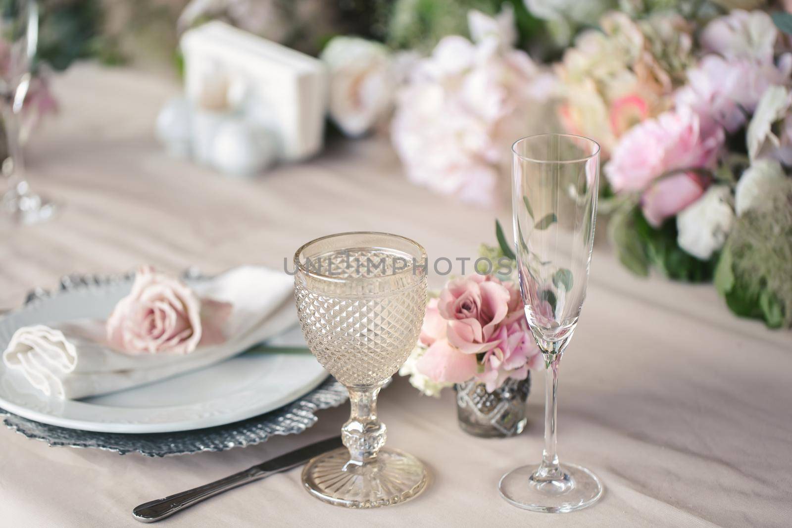 Delicate wedding table setting. A plate with a napkin and a rose by StudioPeace