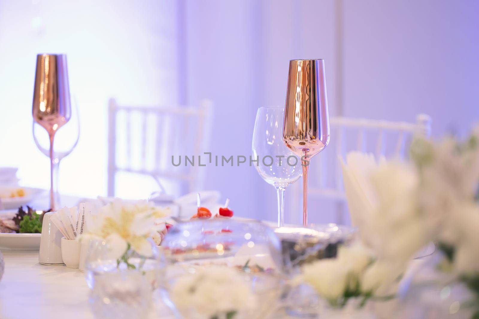 Table at a luxury wedding reception. Beautiful flowers on the table. Serving dishes, glass glasses. by StudioPeace