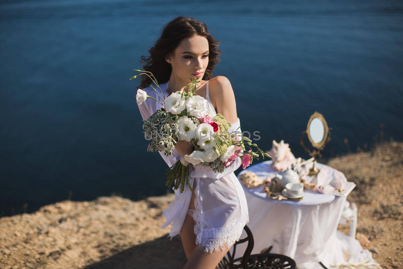 Bride in lingerie. Holds the Bridal bouquet . Charges of the bride, bride's morning.