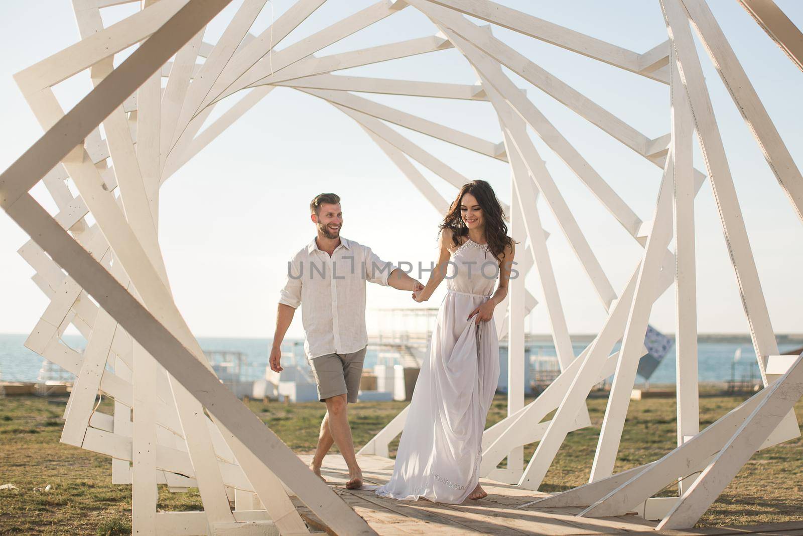 Man and woman posing. Geometric wooden structures. The bride and groom.