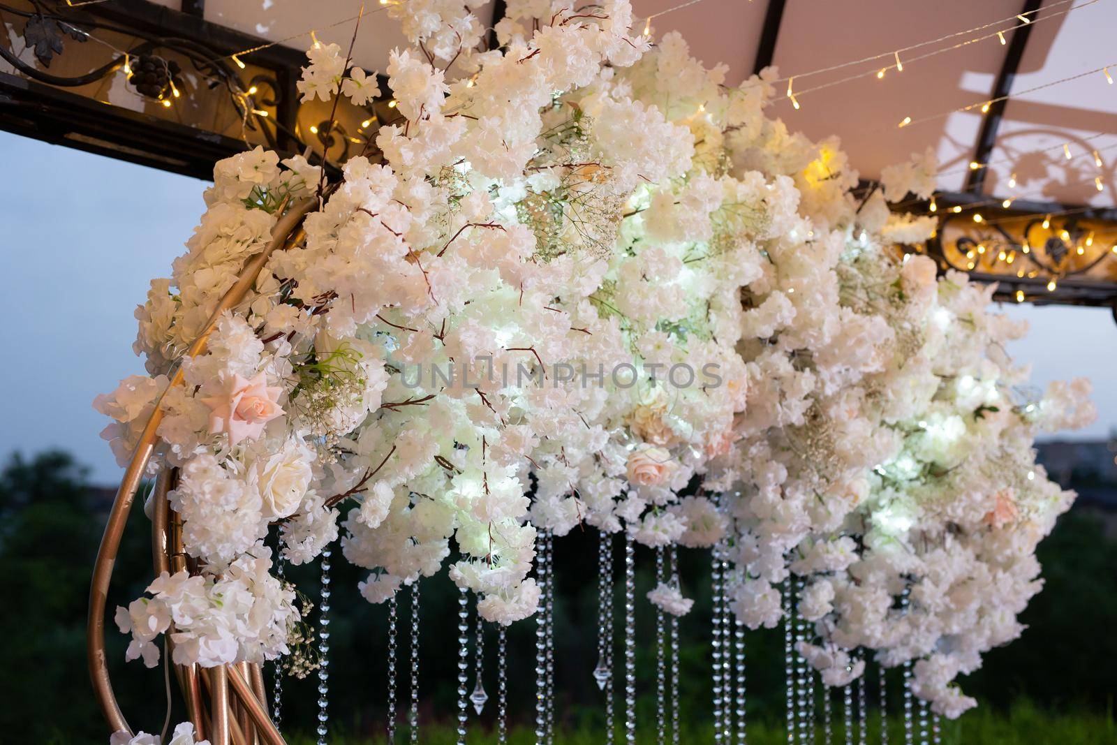 Details of the wedding ceremony made of fresh flowers, sparkling beads. Delicate and beautiful wedding decor for newlyweds.