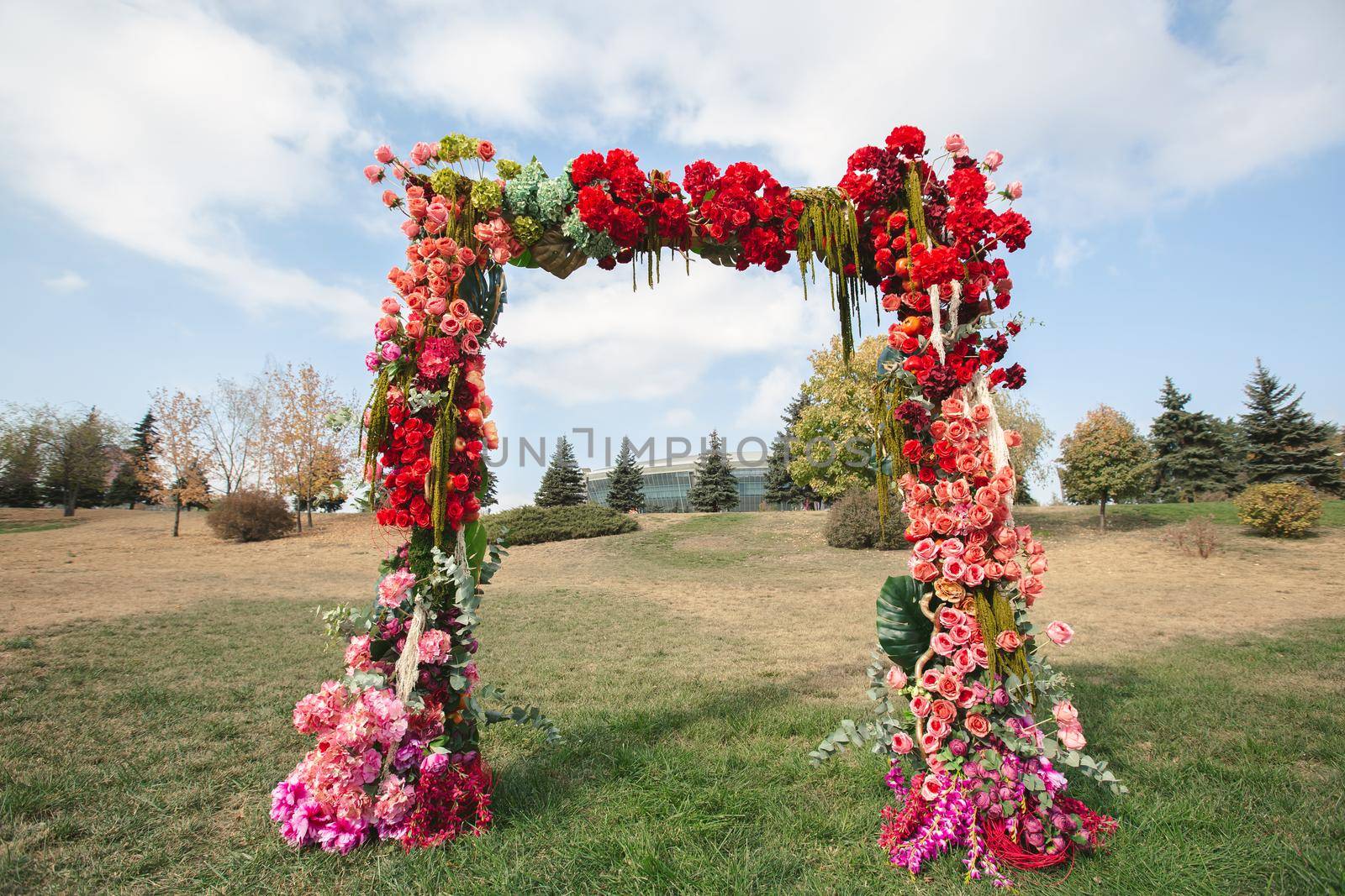 Autumnal wedding arch decoration of roses, apples, grape and pomergranate