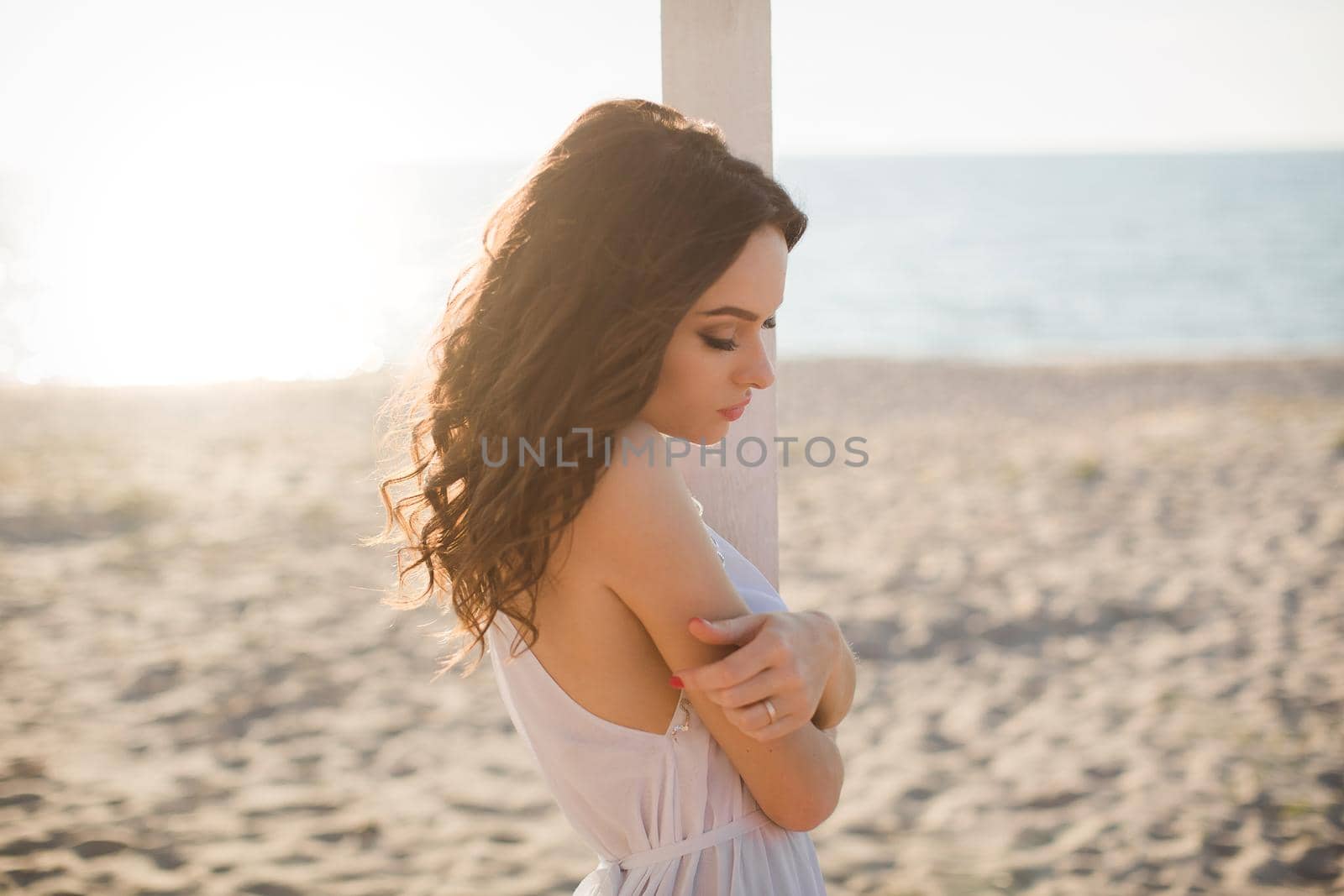 Beautiful girl on the beach in a white dress.