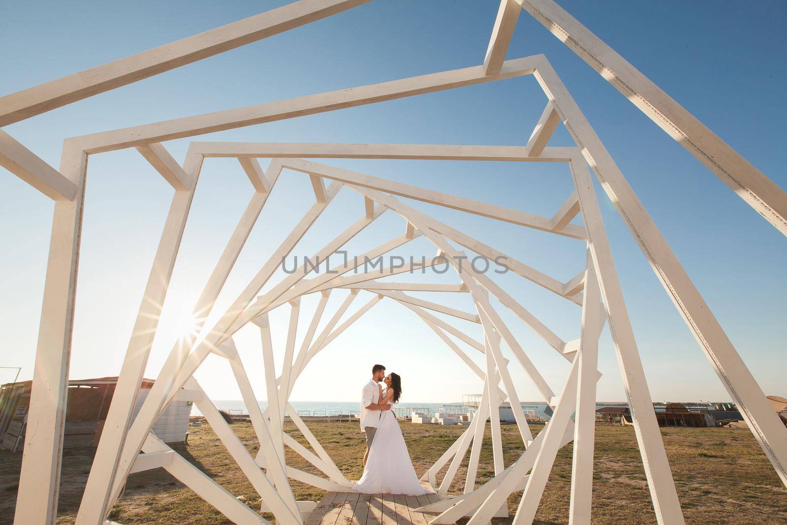 Man and woman posing. Geometric wooden structures. The bride and groom.