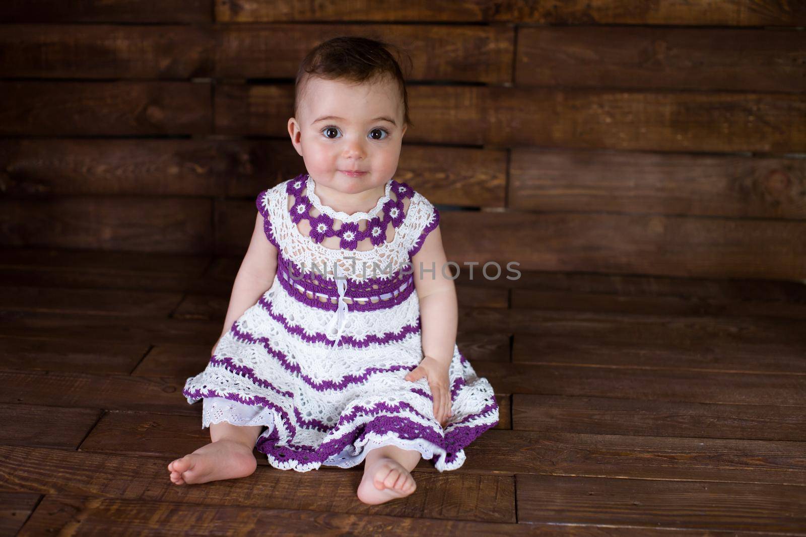 Beautiful girl in pink dress on a wooden background