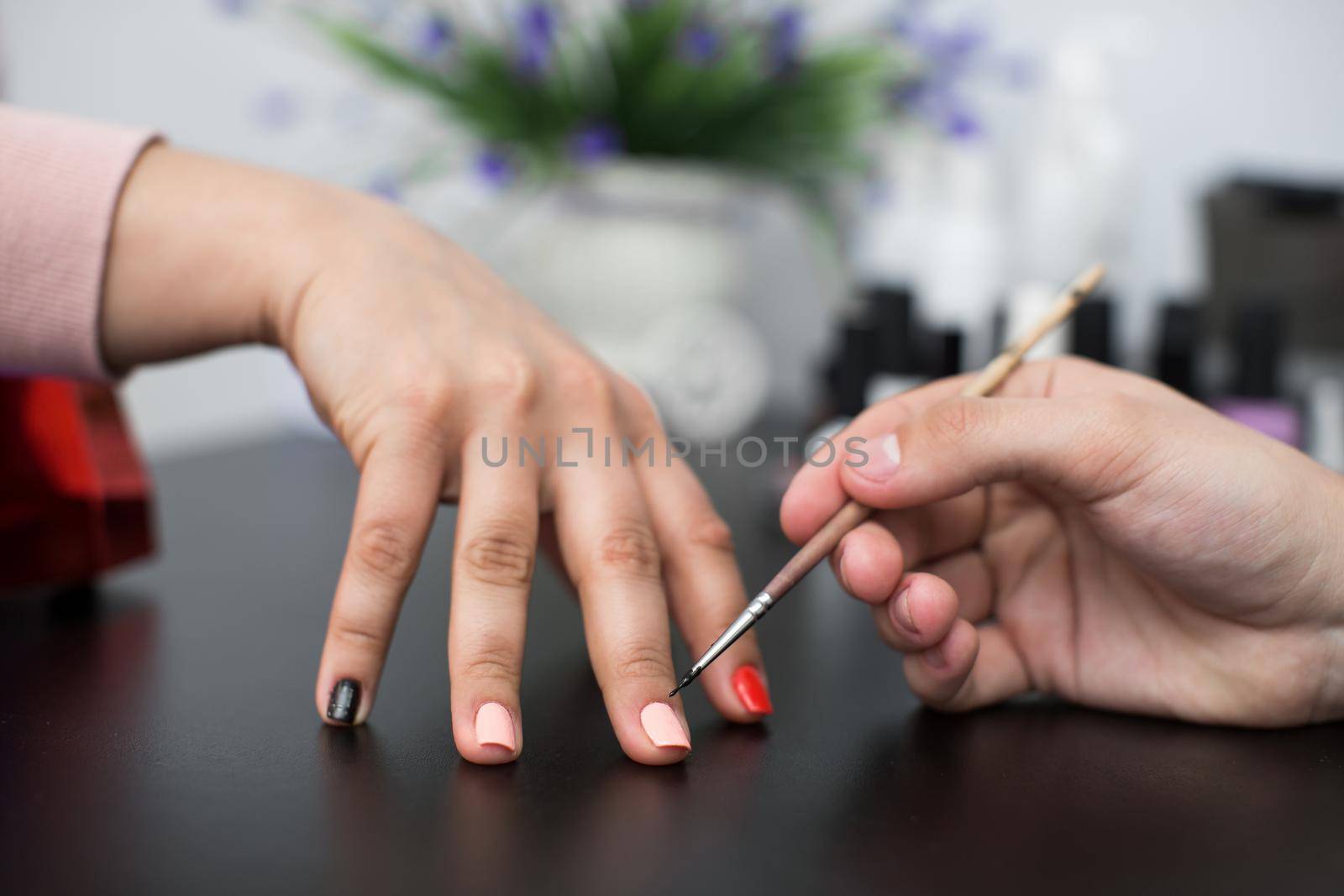 Closeup shot man making manicure to woman in beauty salon. by StudioPeace
